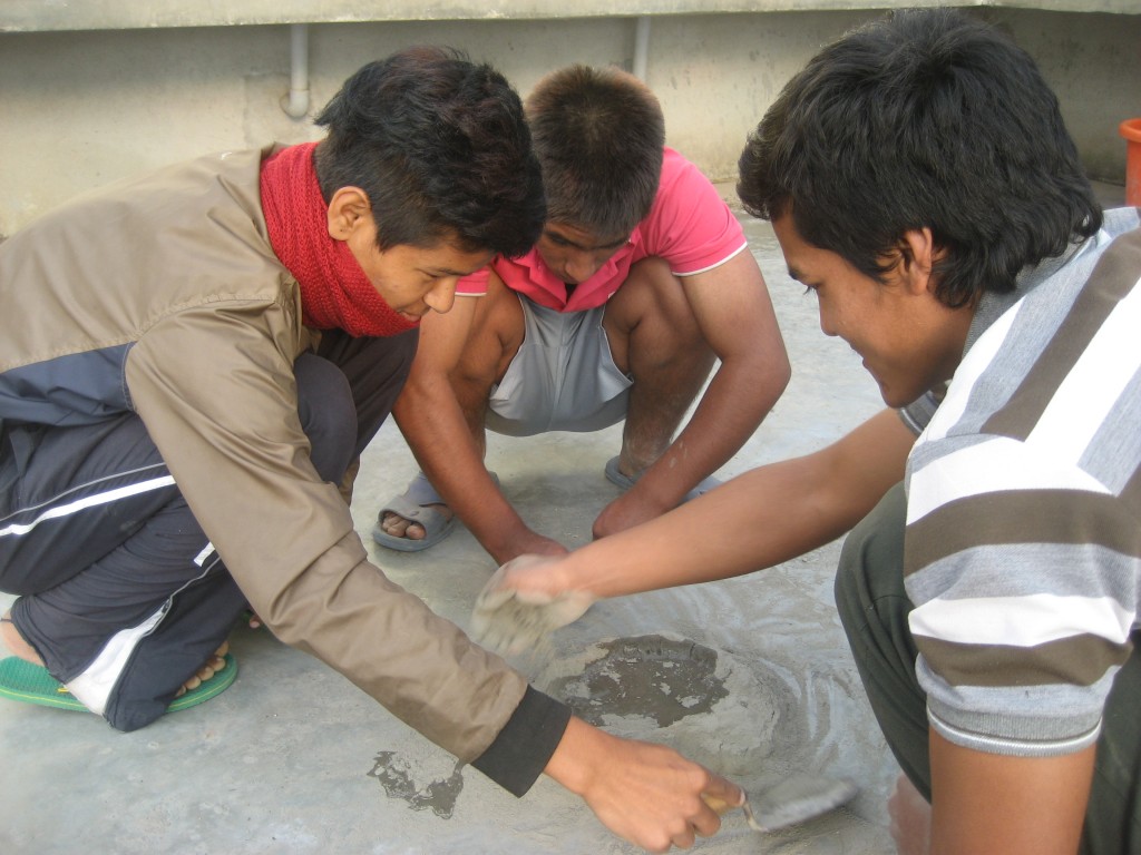Sujan, Kul y Papu haciendo cemento para reparar el gallinero.