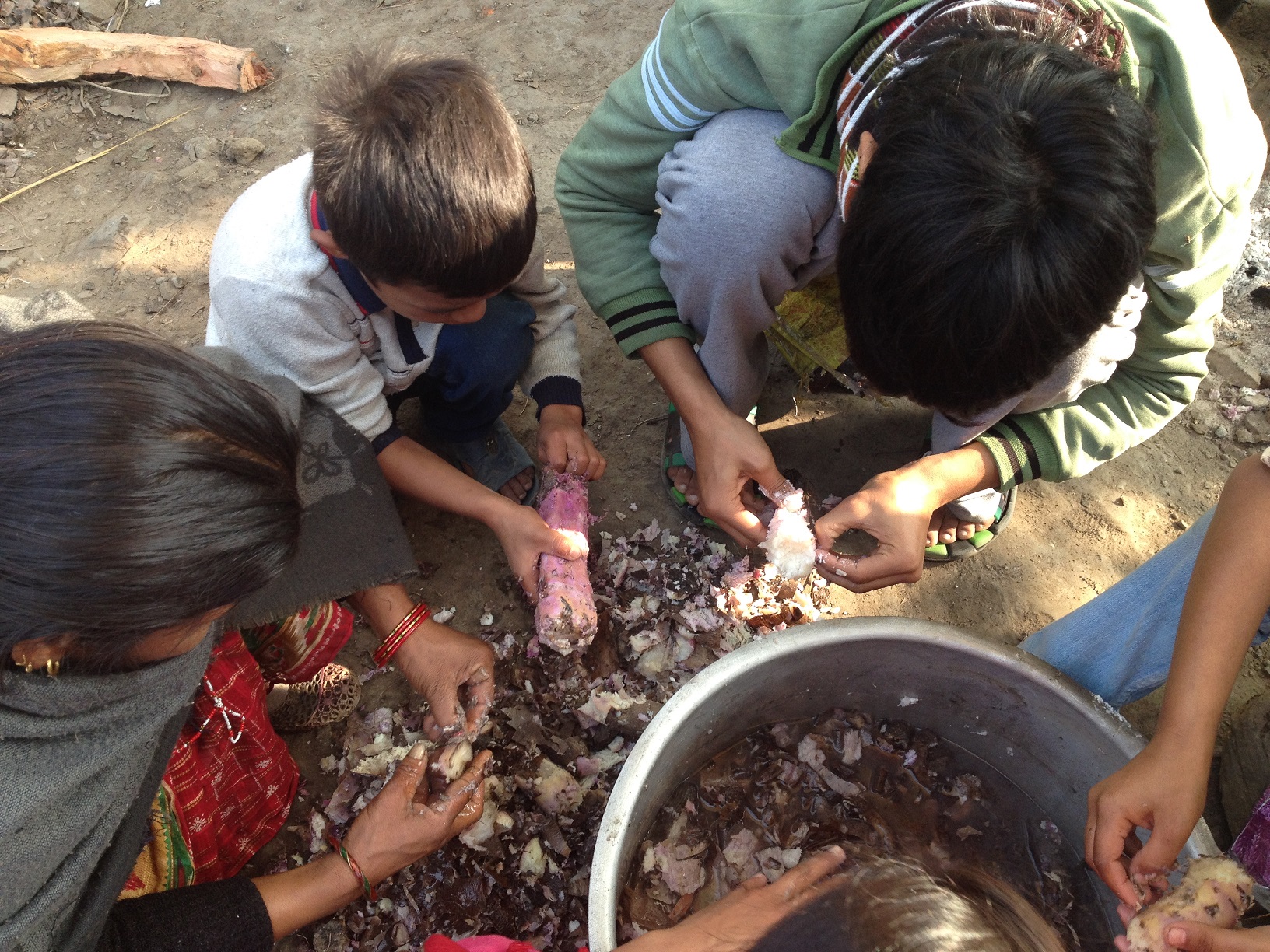 Some kids helping didis to peel thoru.
